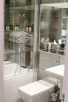 Une salle de bain moderne avec une douche à parois de verre, un lavabo blanc et des toilettes.