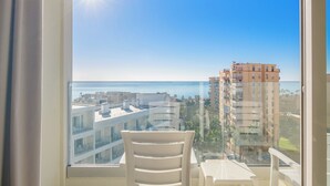 A balcony with a clear view of the sea and surrounding buildings.
