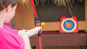 A person holding a bow, aiming at a target with a bullseye. - Hotel Parasol by Dorobe (Torremolinos)