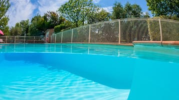 En säsongsöppen utomhuspool, parasoller och solstolar
