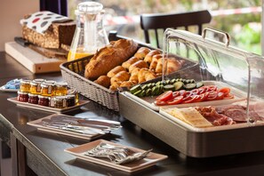 A breakfast buffet with bread, pastries, jams, cheese, meats, and vegetables. - Pointe Isabelle (Chamonix-Mont-Blanc)