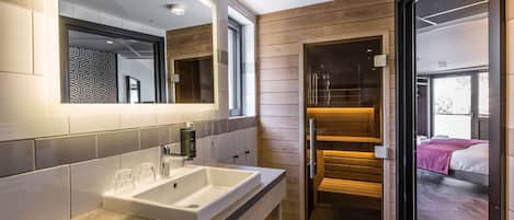 Un baño moderno con un lavamanos grande, dos espejos y un panel de pared de madera.