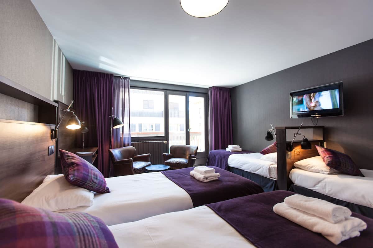 Ett hotellrum med två sängar, en TV, ett skrivbord och en stol.