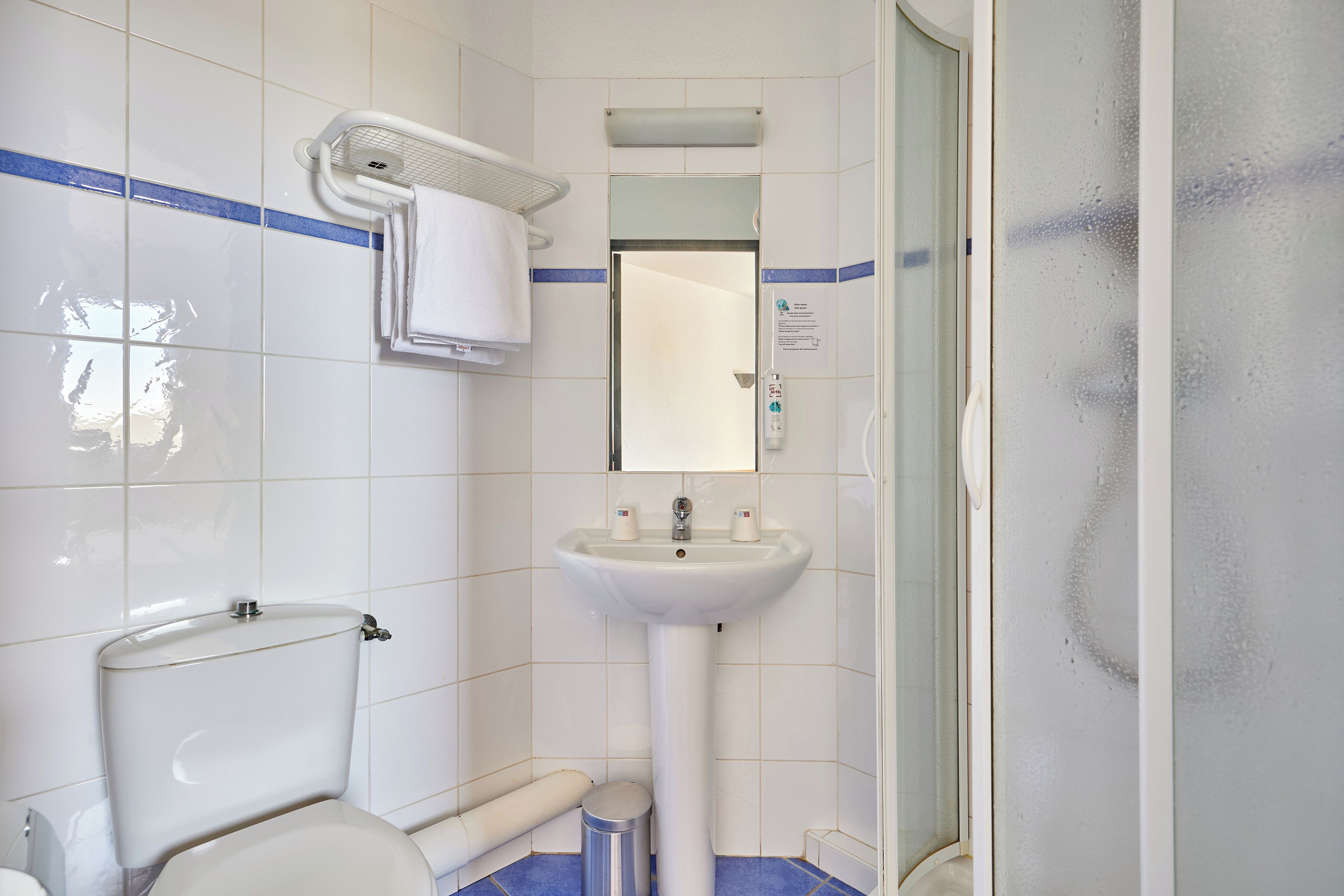 Ein Badezimmer mit Toilette, Waschbecken und Duschbereich.