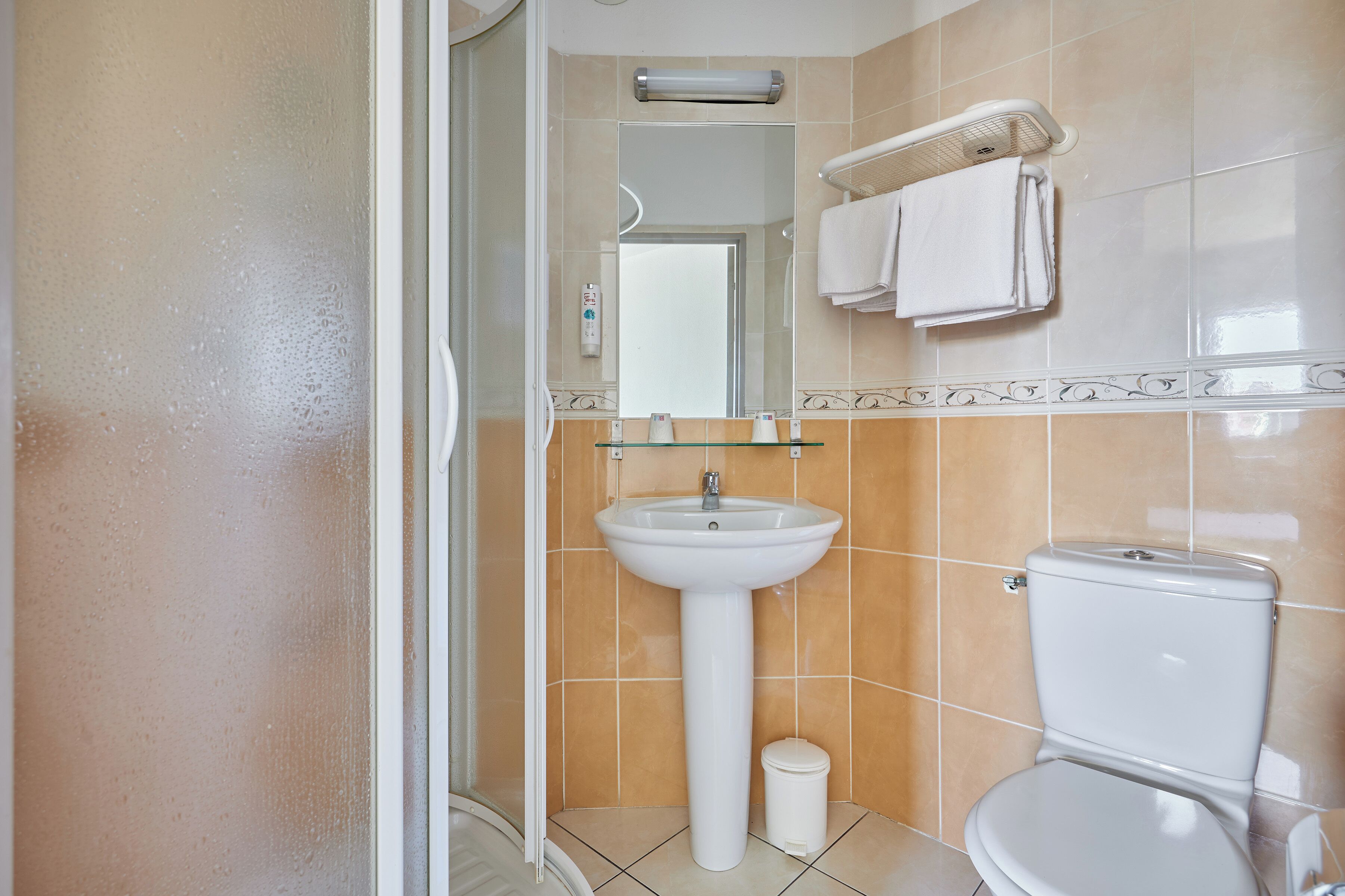 Un baño con lavamanos, inodoro y espejo.