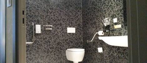 Un baño moderno con inodoro, lavabo y cubo de basura.