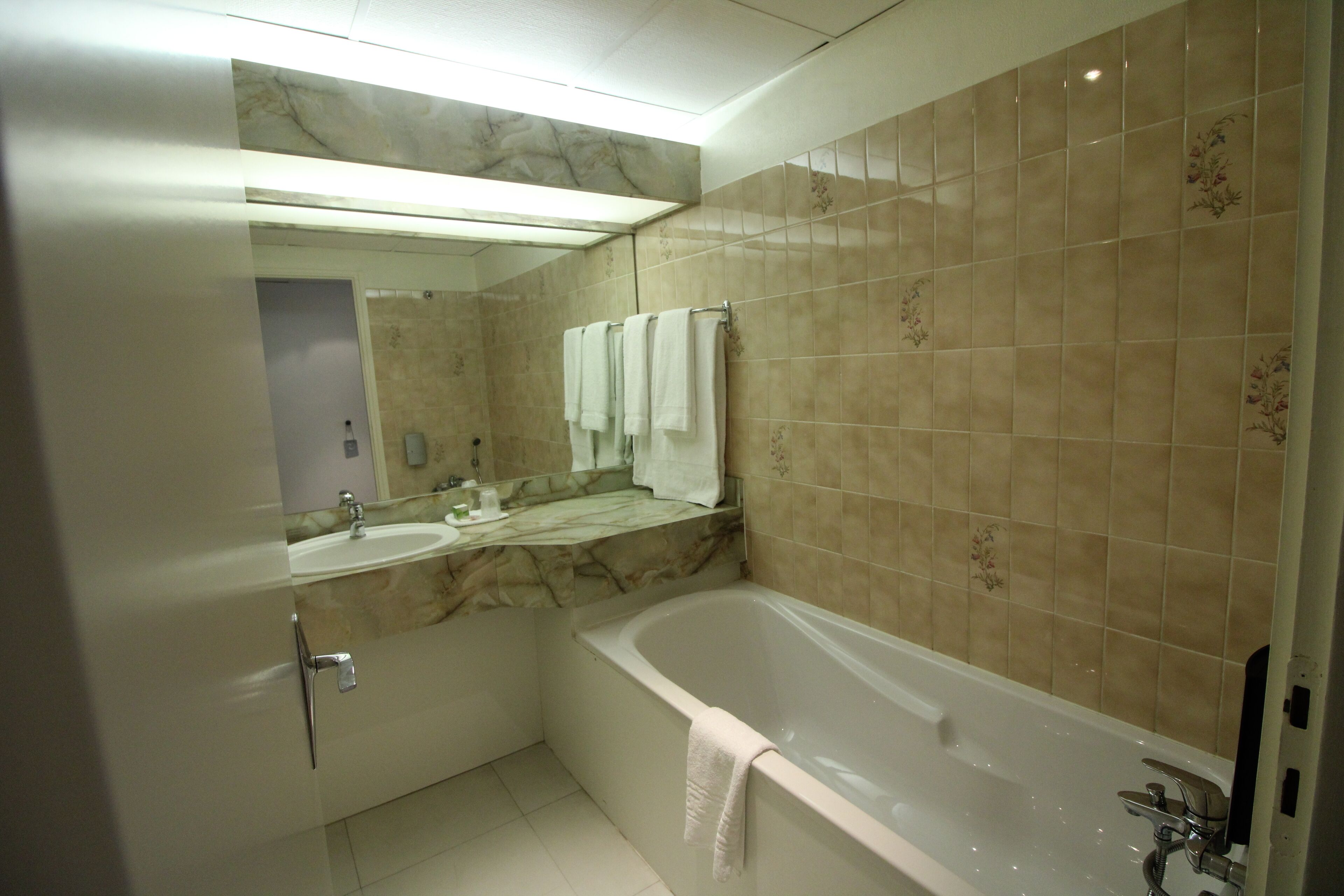 A modern bathroom with a bathtub, a sink, and a mirror.