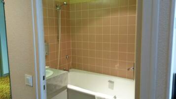 A bathroom with a shower, a sink, and a bathtub.
