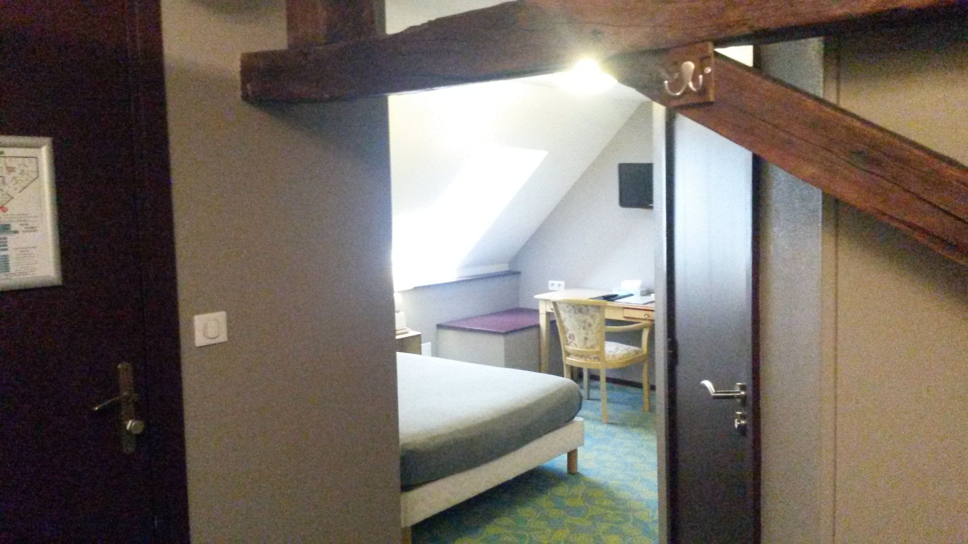 A bedroom with a bed, a desk, and a chair.