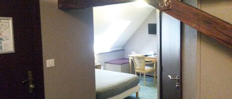 A bedroom with a bed, a desk, and a chair.