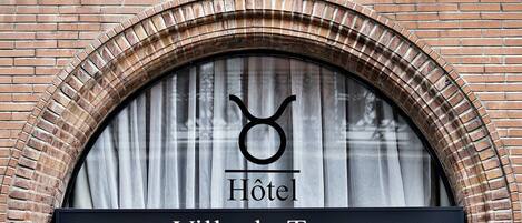 Segnaletica di un hotel con un logo circolare e la scritta "Villa du Taur" sotto.