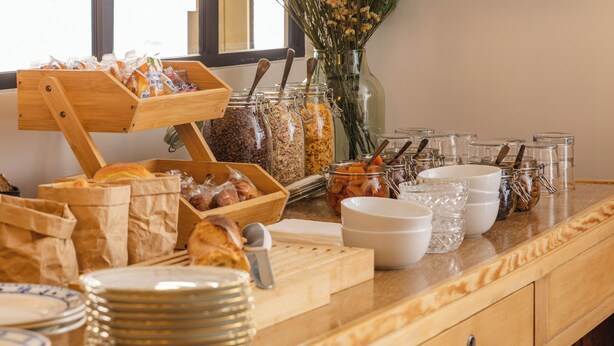 A breakfast buffet setup with various food items and utensils. - Hôtel d'Angleterre (Versailles)