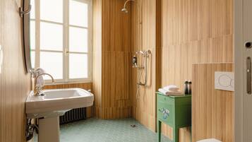 Ein Badezimmer mit Holzwand, Waschbecken, Dusche und einem grünen Schrank.