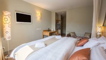 Habitación de hotel con cama, mesita de noche, televisor y armario.