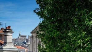 Straatbeeld met een opvallende kerk, gebouwen en een rood voertuig.