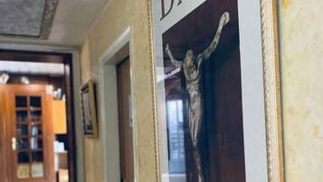 Un pasillo con un cartel enmarcado en la pared, una puerta y una ventana en una habitación con puerta de madera.