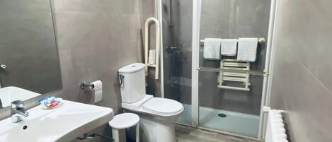 A modern bathroom with a shower, toilet, and sink.