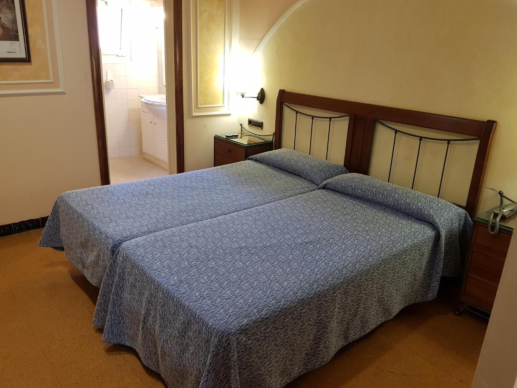 A room with a double bed, a bedside table, and a nightstand.