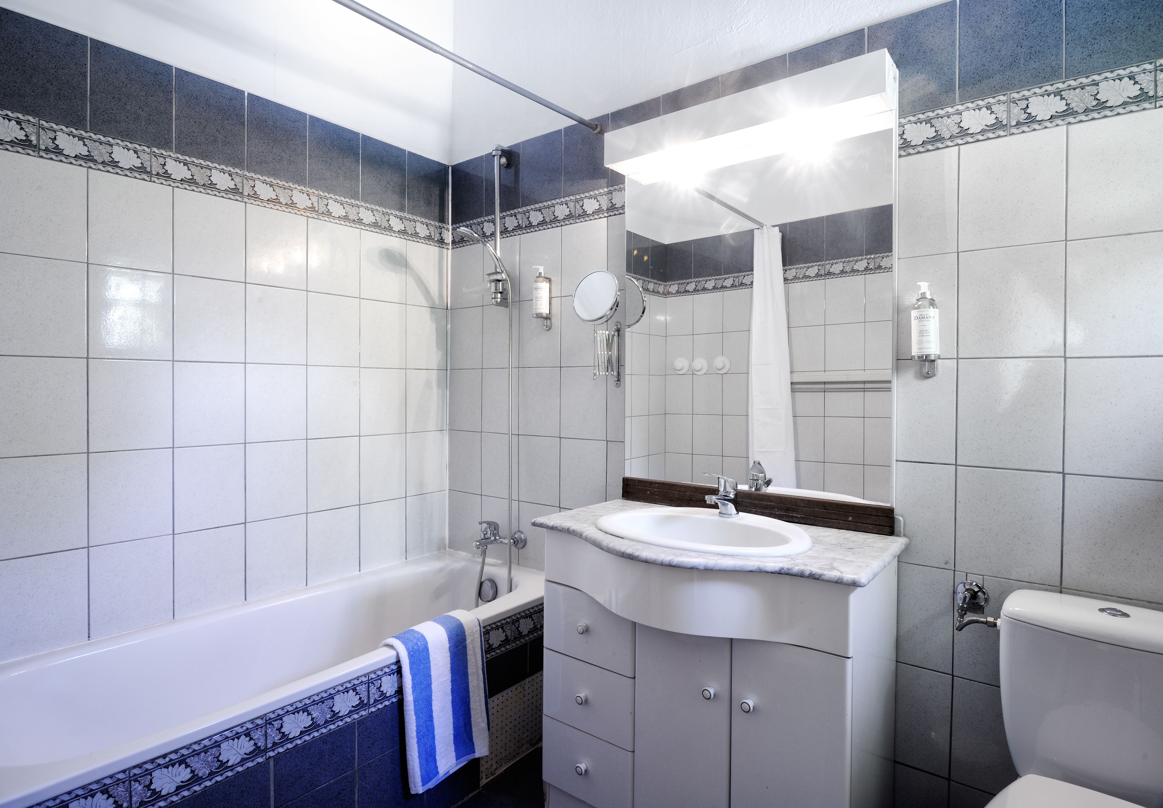 Ein Badezimmer mit Badewanne, Waschbecken, Spiegel und Toilette.
