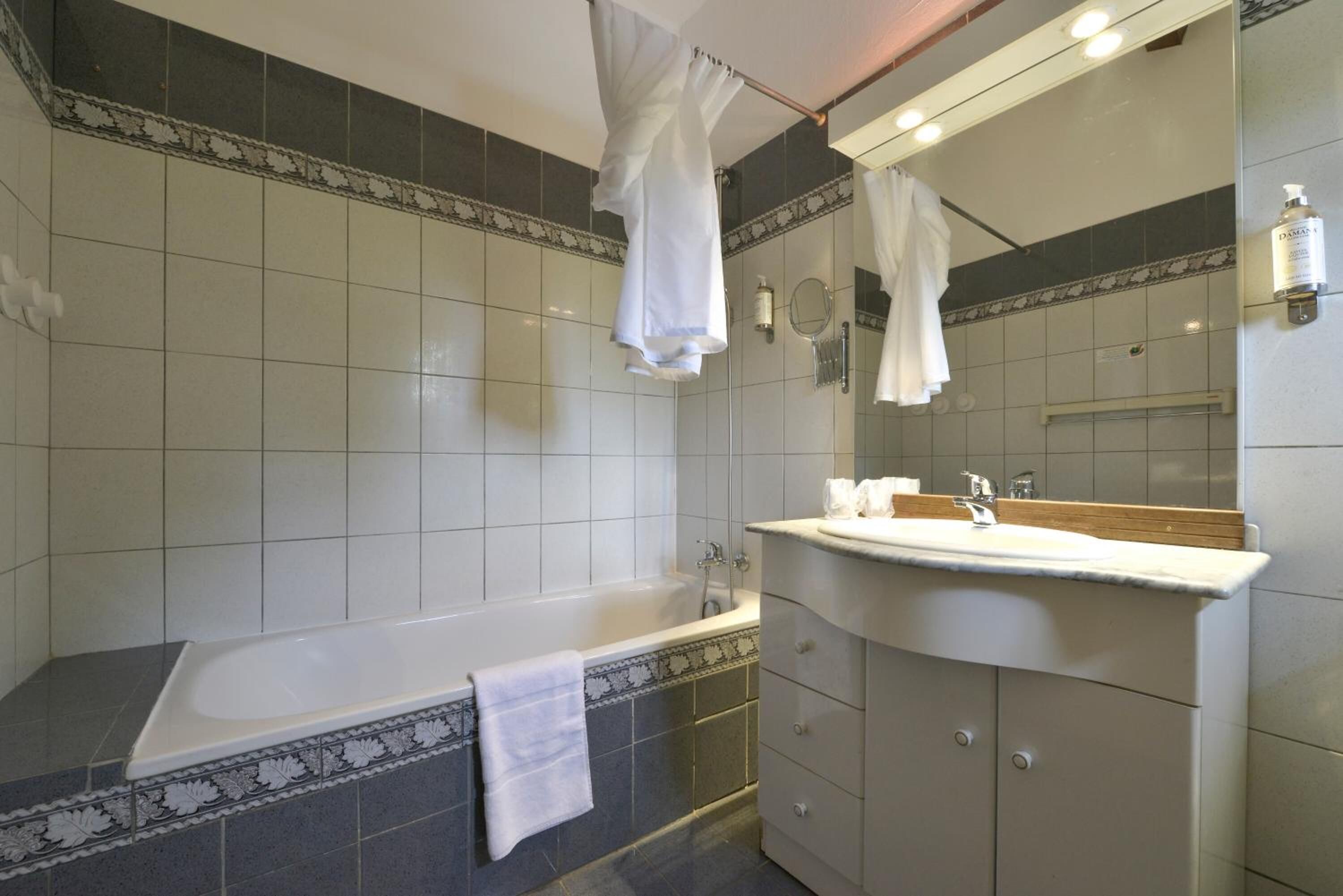 A modern bathroom with a bathtub, a vanity with a mirror, and a shower area.