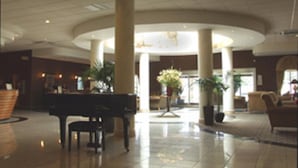 A spacious lobby with a central seating area, large pillars, and a reception desk. - Holiday Inn Barnsley by IHG (Barnsley)