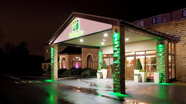 A Holiday Inn with a brick facade and a covered entrance area.