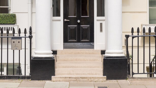 A hotel entrance with a classic facade, a sign above the door, and a black gate. - Mornington Hotel London Victoria (London)