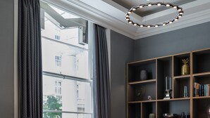 A room with a large window, a bookshelf, and two chairs. - Mornington Hotel London Victoria (London)