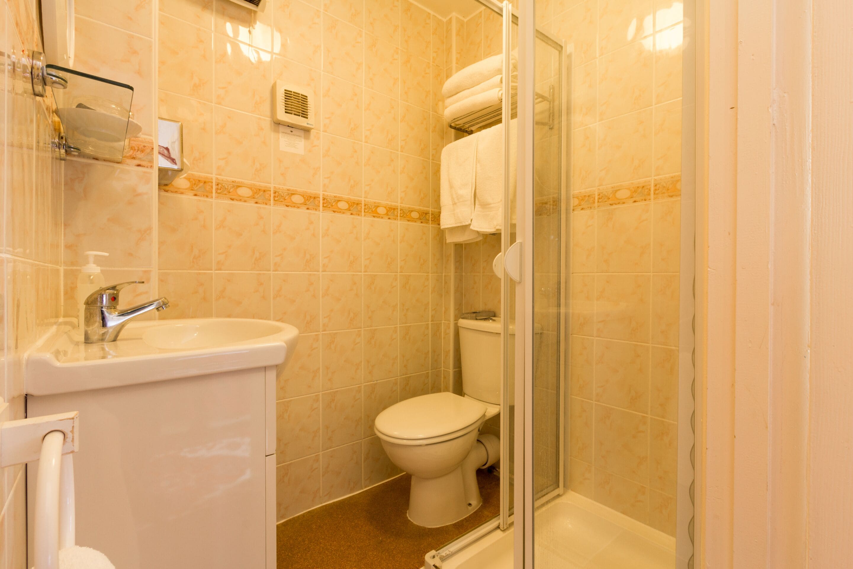 A bathroom with a sink, toilet, and glass-enclosed shower.