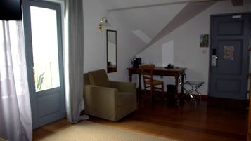 Ein Zimmer mit einem Stuhl, einem Tisch, einem Spiegel und einer Tür.