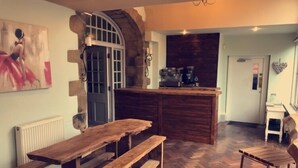 A rustic kitchen with a wooden bench and a herringbone-patterned floor. - Kings Head Hotel (York)