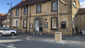 A traditional stone building with a sign reading "Kings Head Hotel." - Kings Head Hotel (York)