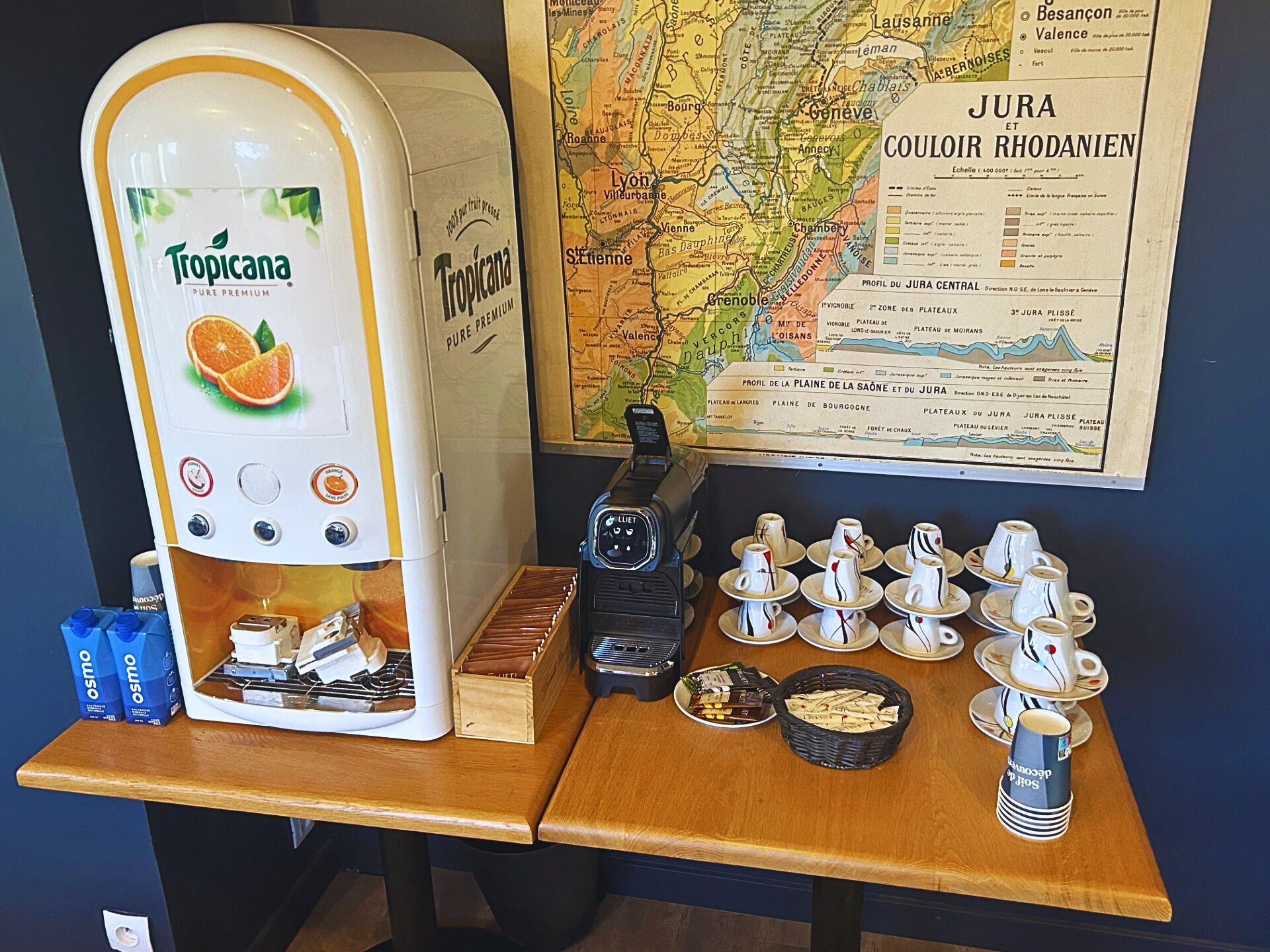 Una cafetera, una radio y una mesa con tazas y pasteles.