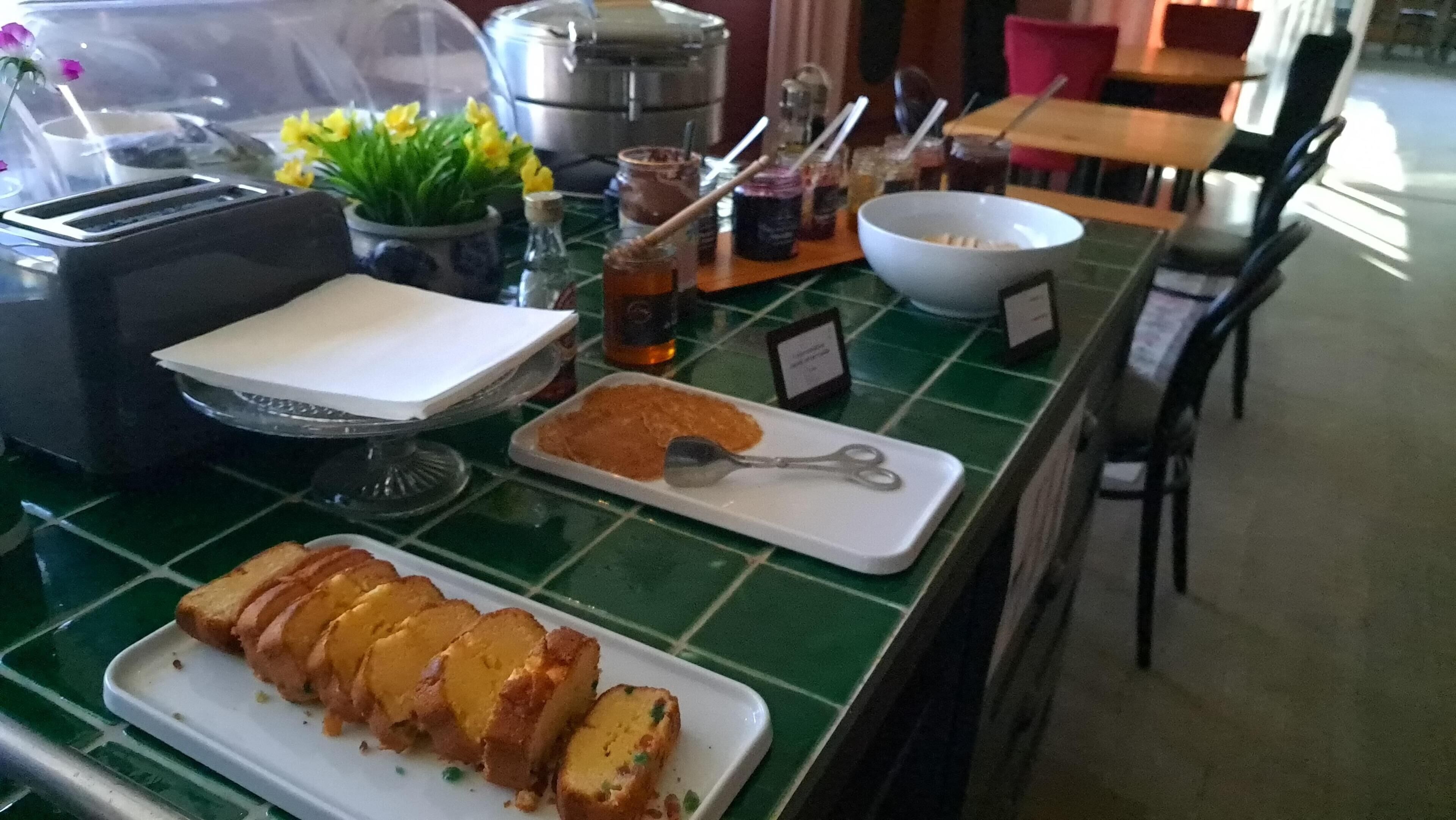 A breakfast buffet with various food items, a toaster, and a coffee machine.