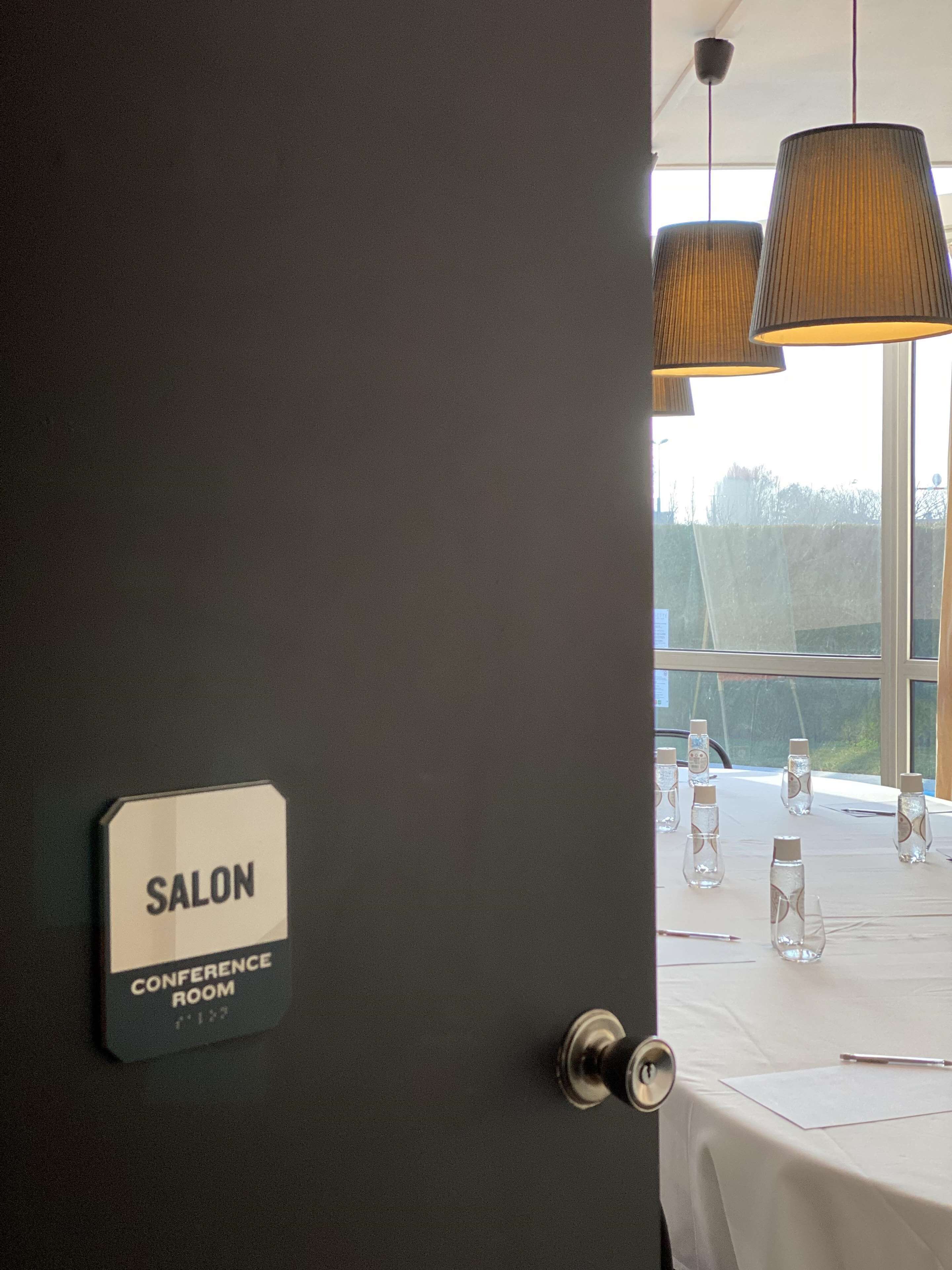 Ein Konferenzraum mit einem Schild, das ihn als Salon kennzeichnet.