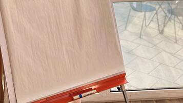 A whiteboard with "Welcome on board!" written on it, placed near a window overlooking a swimming pool.