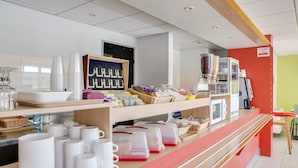 Una barra bien organizada con diversos objetos, como tazas, recipientes y una máquina de café.