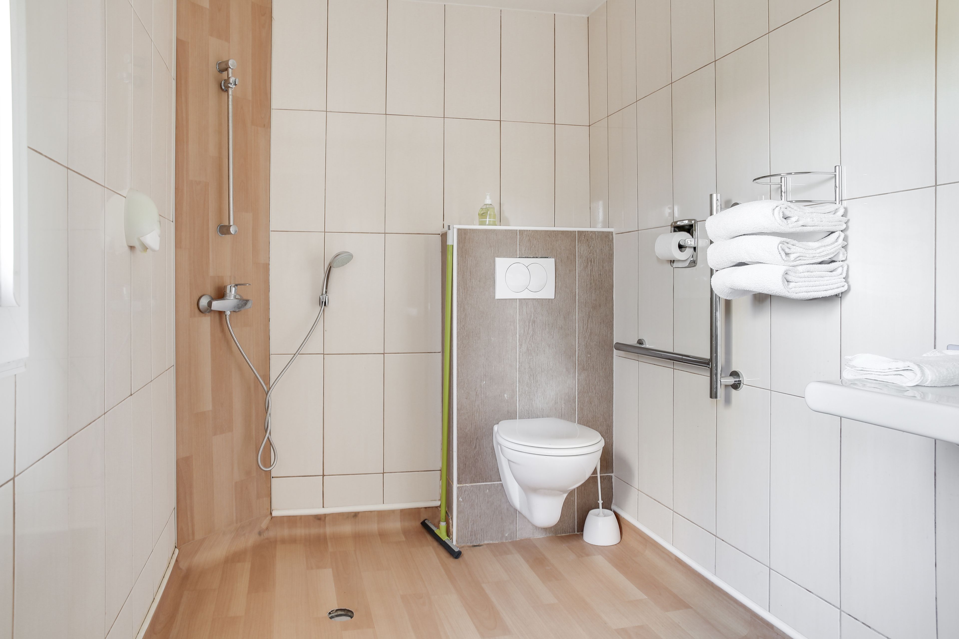Un bagno moderno dotato di doccia, wc e porta asciugamani.