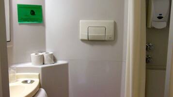 A small bathroom with a toilet, sink, and shower curtain.