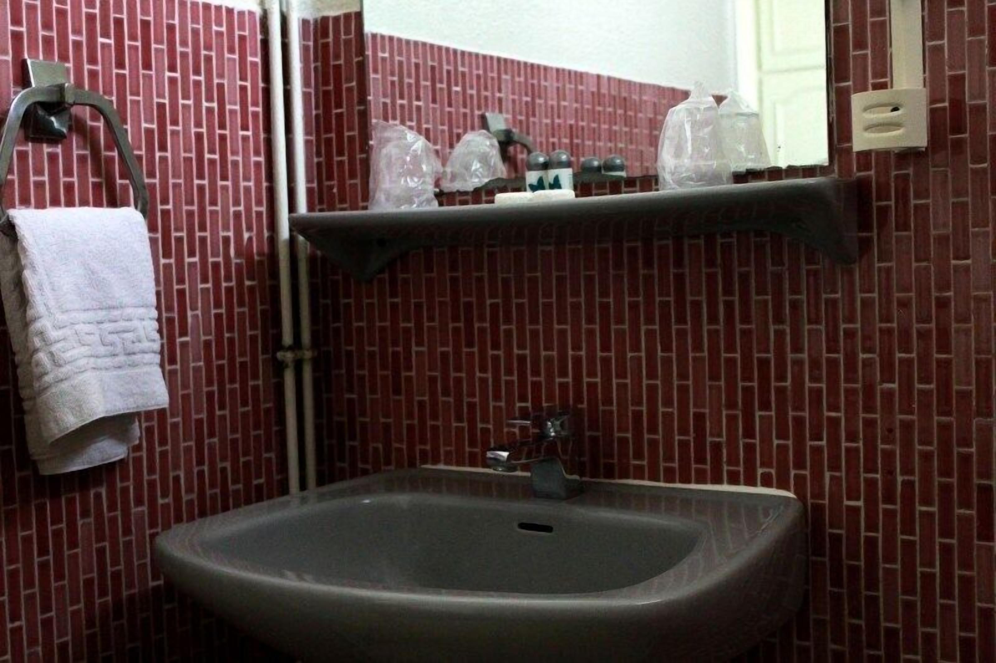 A bathroom with a sink, a towel rack, and a mirror.