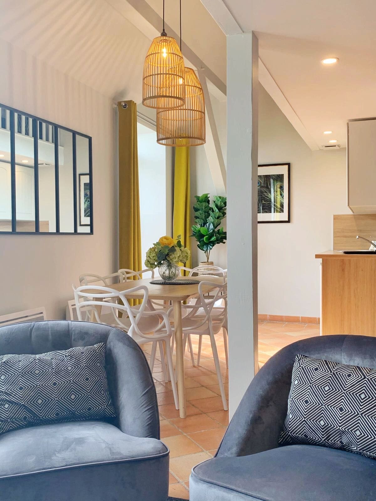 Una sala de estar moderna con comedor, cocina y escalera.