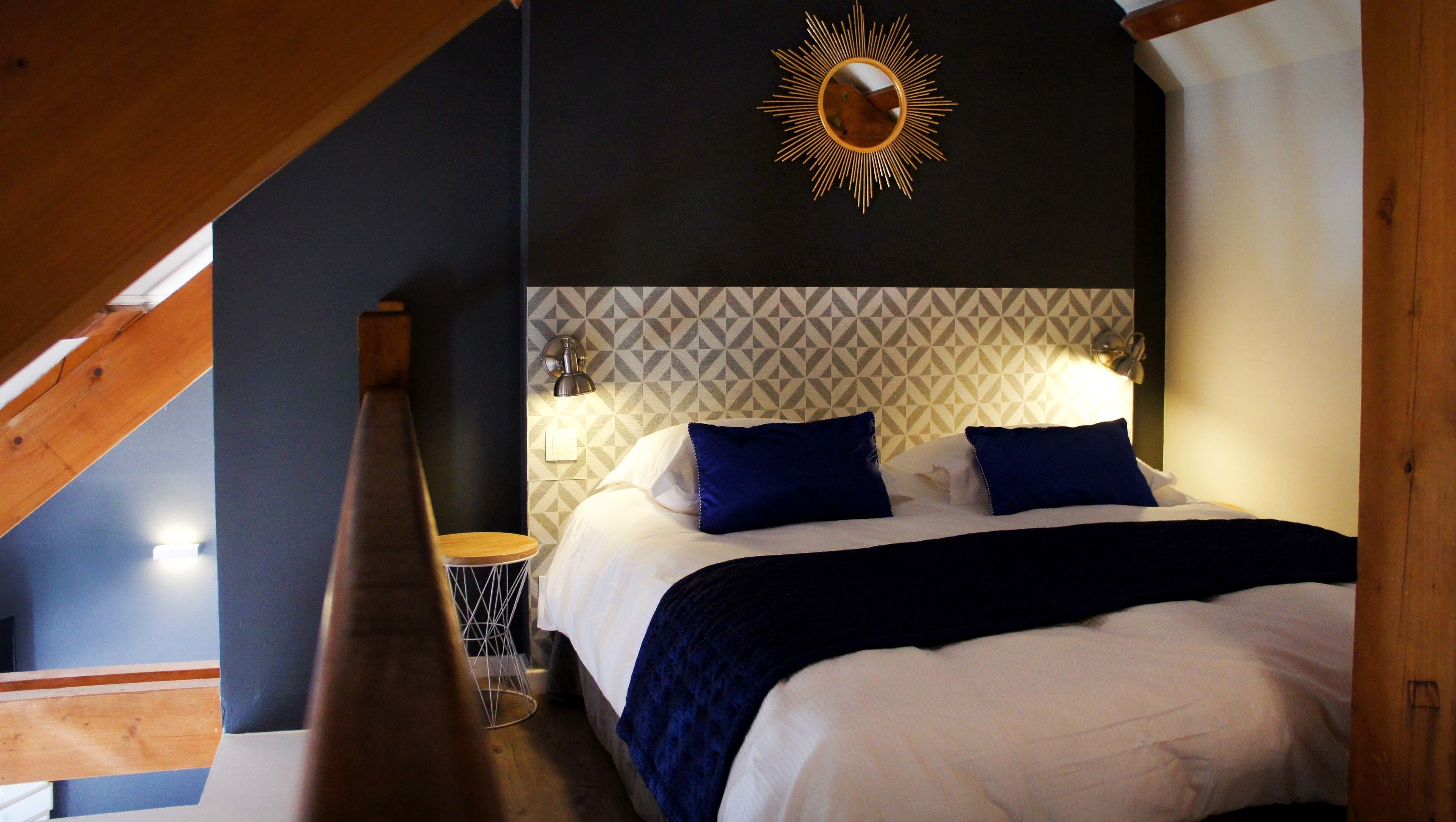 Una camera da letto con un letto, un comodino, una lampada e una decorazione solare a parete.