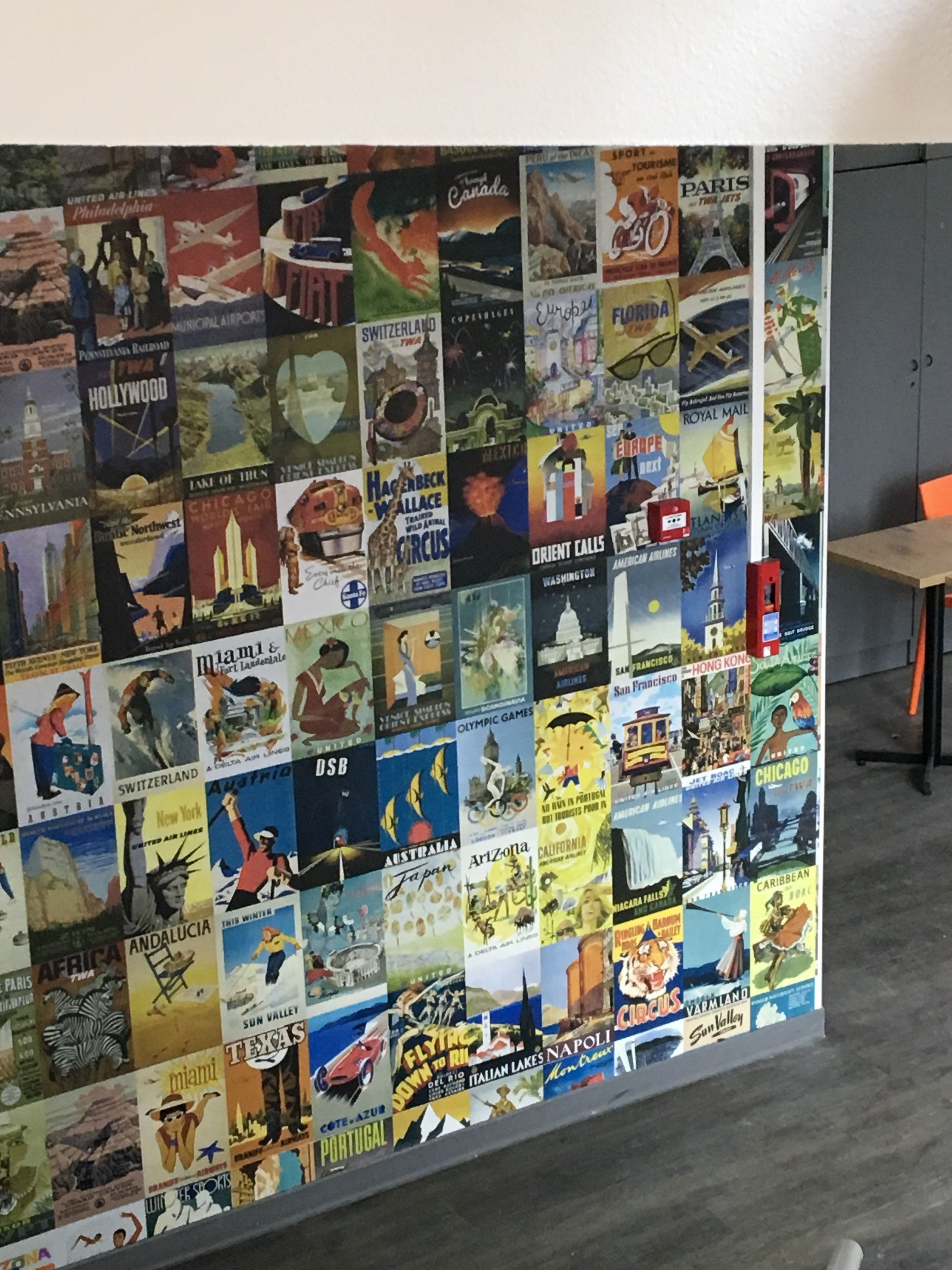 Una pared decorada con carteles de viaje antiguos que muestran diferentes destinos.