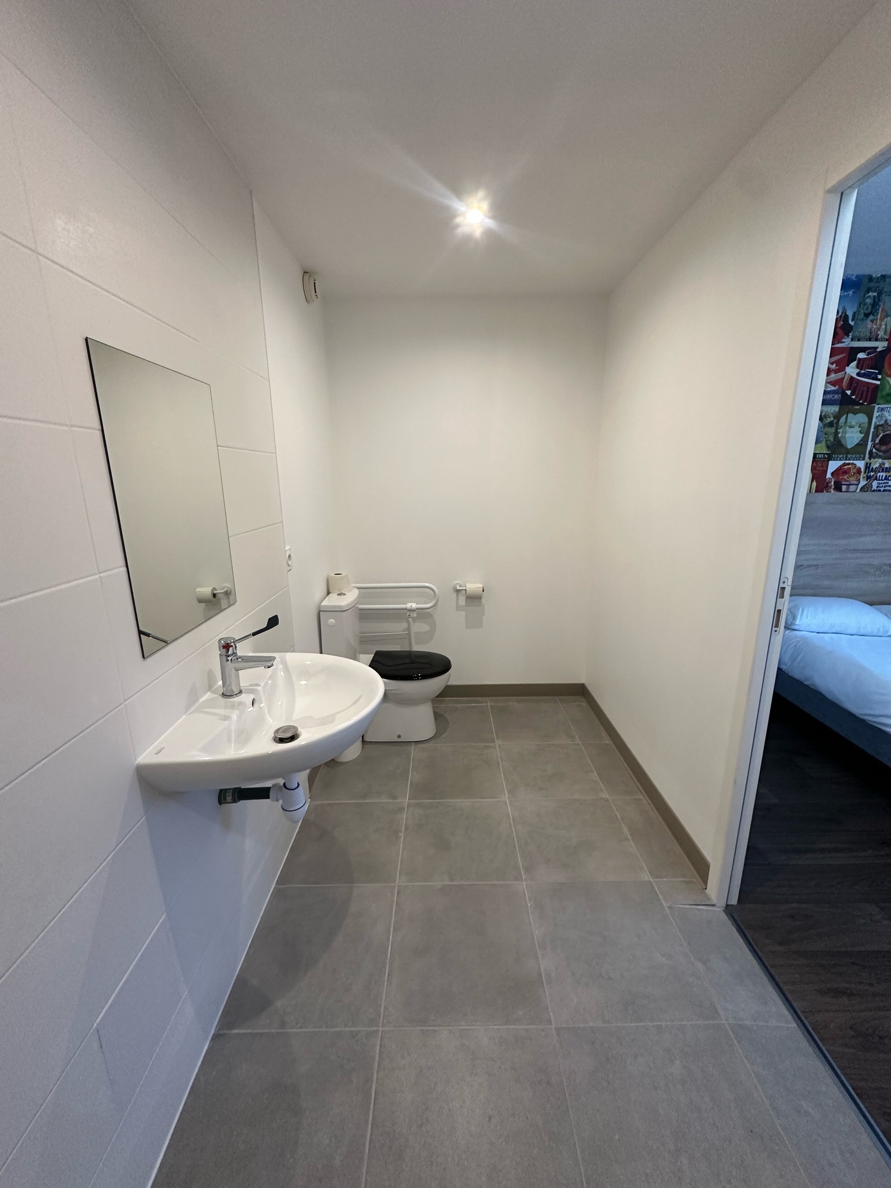 A modern bathroom with a sink, toilet, and mirror.