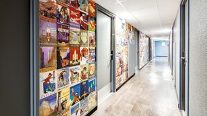 A hallway with posters of various cities and landmarks on the walls. - hotelF1 Bourges Le Subdray (Le Subdray)