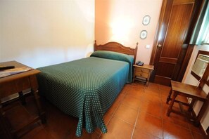 A bedroom with a wooden bed, a bedside table, a chair, and a desk. - Zaida (Seville)