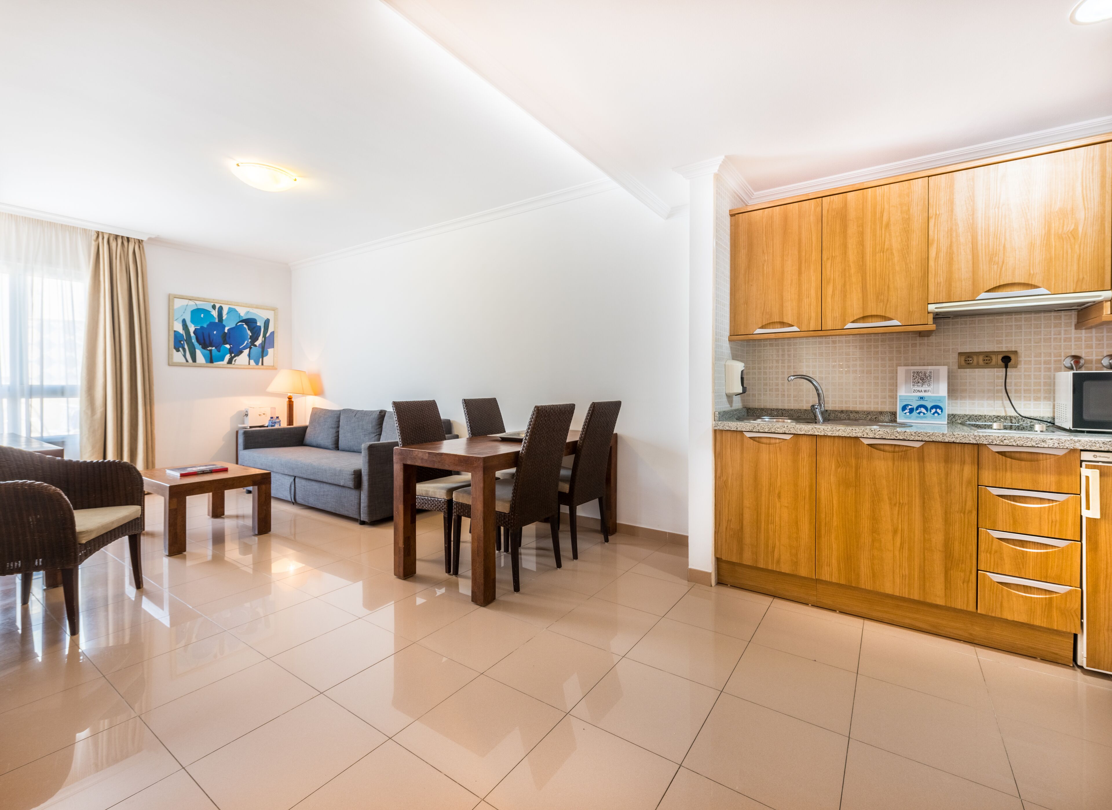 A modern apartment with a dining area, a living room, and a kitchen.