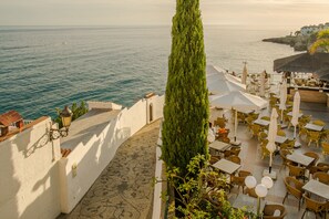 An outdoor terrace with tables and chairs, overlooking the sea. - Toboso Apar-Turis (Nerja)