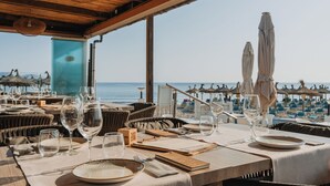 Un restaurante frente al mar con mesas dispuestas para comer, con vista al océano.