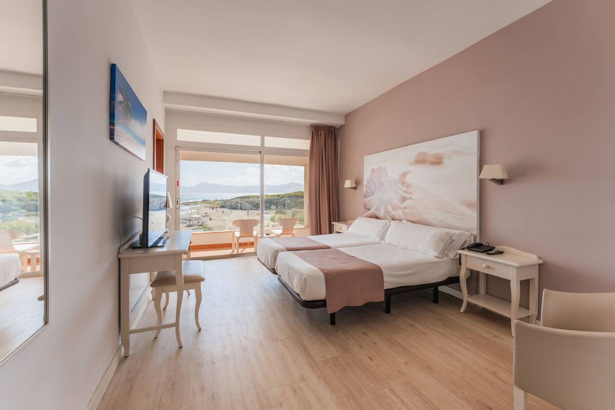 Een moderne hotelkamer met een groot bed, een bureau, een stoel en een televisie.